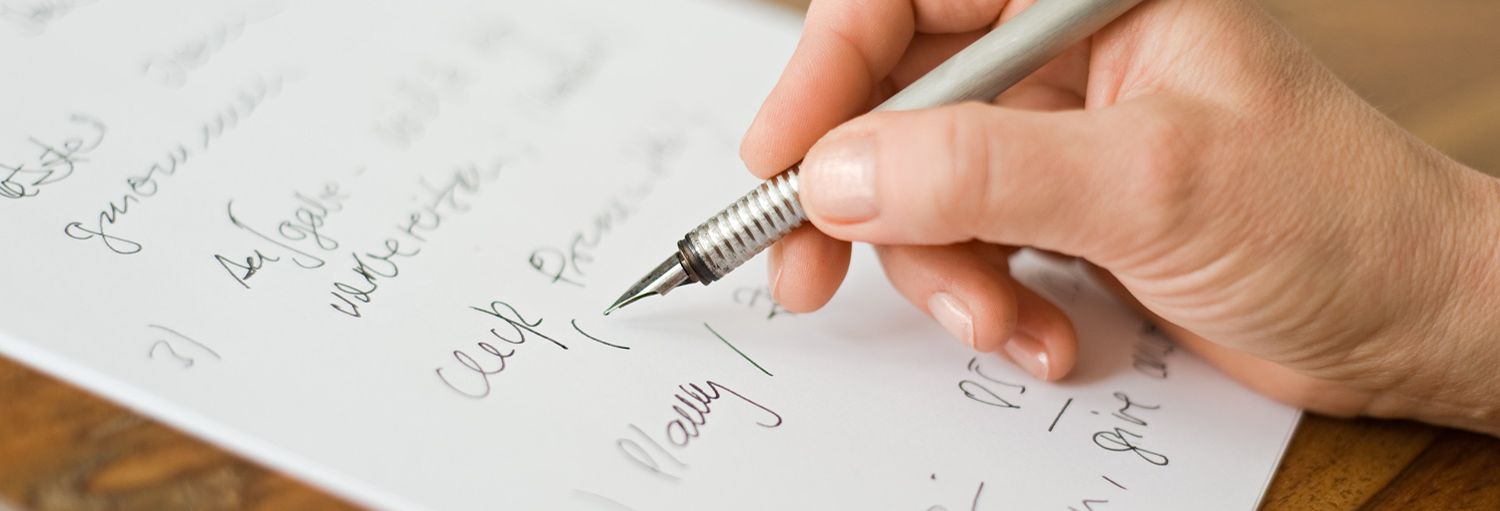 Frau schreibt mit einem Füller auf einen Notizblock mit einem Füller